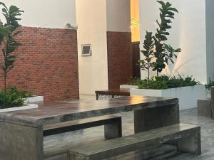 a wooden bench in a room with plants at Chambers Suites KL in Kuala Lumpur