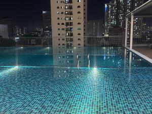 a swimming pool on the roof of a building at night at Chambers Suites KL in Kuala Lumpur