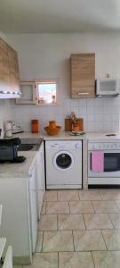 Petreto-BicchisanoにあるCasa Di Minnanaのキッチン(食器洗い機、洗濯機付)