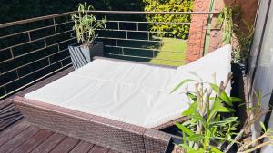 a wicker bench sitting on a wooden deck at Pod Świerkami in Boszkowo