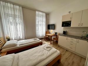 ein Hotelzimmer mit 2 Betten und einer Küche in der Unterkunft AJO Vienna Messe - contactless check in in Wien