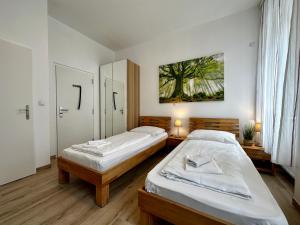 ein Schlafzimmer mit 2 Betten und einem Wandgemälde in der Unterkunft AJO Vienna Messe - contactless check in in Wien