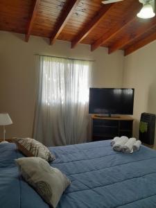 1 dormitorio con 2 camas y TV de pantalla plana en Departamento La Trinidad en Merlo