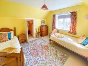 a bedroom with two beds and a window and a rug at The Gate Lodge in Latheron