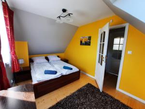 a bedroom with a bed and a yellow wall at Domek do wynajęcia - Siedlisko przy lesie in Rząśnik