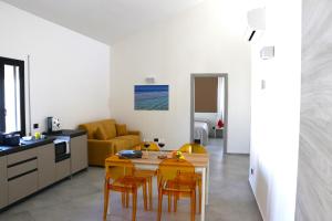 uma cozinha e sala de estar com mesa e cadeiras em Elimi Home Appartamenti em Nuova Gibellina