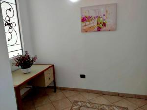 een kamer met een tafel en een schilderij aan de muur bij Casa Federica in Taviano