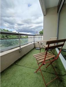 - un balcon avec un banc et une table dans un bâtiment dans l'établissement Appartement sans vis à vis à 2 min de la rocade, à Rennes