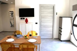 uma sala de jantar com uma mesa de madeira e cadeiras em Elimi Home Appartamenti em Nuova Gibellina