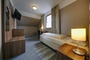 ein Hotelzimmer mit einem Bett und einem TV in der Unterkunft Gasthaus Mooshäusl in Hebertshausen