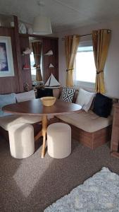 a living room with a table and a couch at Crimdon dene bay view holiday home NO SMOKING NO PETS in Durham