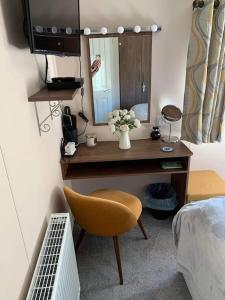 a bedroom with a desk with a mirror and a chair at Crimdon dene bay view holiday home NO SMOKING NO PETS in Durham