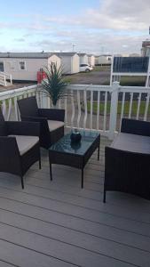 a patio with chairs and a table on a deck at Crimdon dene bay view holiday home NO SMOKING NO PETS in Durham