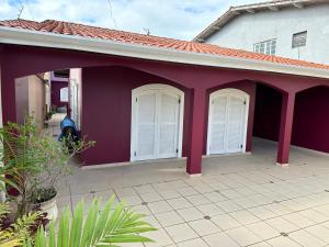 a purple house with white doors and a patio at Casa no Centro de Bertioga com Piscina in Bertioga