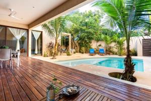 a house with a wooden deck with a swimming pool at Casa Esperanza Tulum Private Pool in Tulum