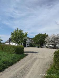 a dirt road in front of a white house at Öja in Ystad
