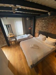 a bedroom with a large white bed and a brick wall at Taxim No18 Boutique Hotel in Istanbul