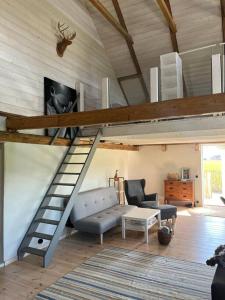 sala de estar con cama elevada y sofá en Öja en Ystad