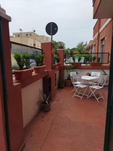 d'une terrasse avec des chaises et des plantes en pot sur un balcon. dans l'établissement Appartamento Elena & Chiara, à Rome