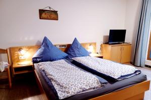 um quarto com 2 camas e almofadas azuis em Bayern Ferienland Sonnenwald em Schöfweg