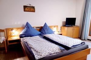 una camera da letto con due letti con cuscini blu di Schönblick 36 a Schöfweg