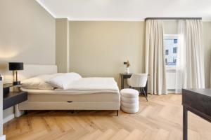 a white bedroom with a bed and a table at Premium Room 'The Port' - HBF-Messe-ÖVB Arena-City in Bremen