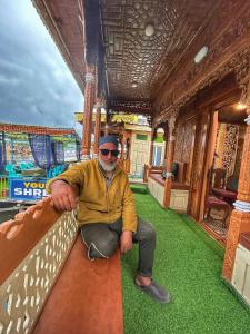 un hombre está sentado en un tren en Heritage Shreen Houseboat en Srinagar