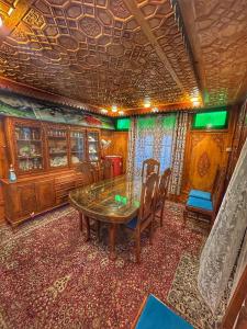 a dining room with a wooden table and chairs at Heritage Shreen Houseboat in Srinagar