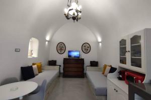 a living room with a couch and a table at Dreamer's Secret villa 2 in Emporio Santorini