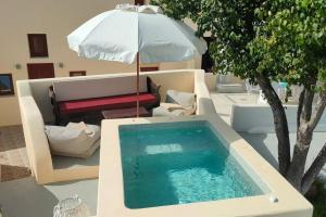 Emporio的住宿－Dreamer's Secret villa 2，一个带遮阳伞的游泳池,旁边是一张桌子