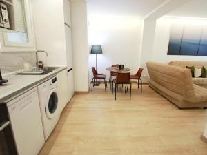 a kitchen and living room with a couch and a table at Nuevo Hola Madrid Alojamiento Temporal in Madrid +16 photos