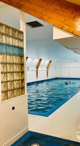 a swimming pool with blue water and wooden ceilings at Chalet 190 La Belle Durbuy in Durbuy