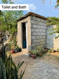 un pequeño edificio de ladrillo con una puerta en un patio en Tina Transient Home en Cayluya