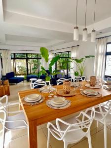 comedor con mesa de madera y sillas blancas en Villa Hacienda 4 en Cap Malheureux