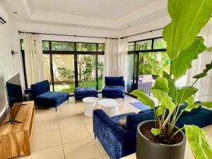 a living room with blue couches and a plant at Villa Hacienda 4 in Cap Malheureux