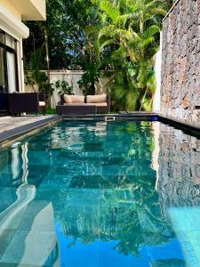una piscina de agua azul frente a una casa en Villa Hacienda 4 en Cap Malheureux