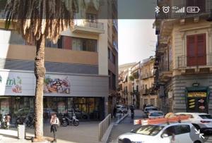 a city street with cars and a palm tree at Montesanto House Palermo in Palermo