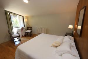 San Xulián de SalesにあるPazo Cibránのベッドルーム1室(白いベッド1台、枕2つ付)