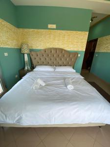 een groot wit bed met twee witte handdoeken erop bij Prince Hotel Fier in Fier