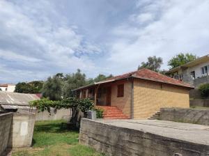 een klein bakstenen huis met een stenen muur bij Villa Kassel in Stari Bar