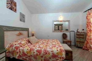 a bedroom with a bed and a dresser and a mirror at Tenuta Petra Manna in Palau
