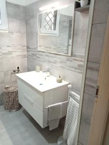 uma casa de banho com um lavatório branco e um espelho. em Casa Paky em Punta Prosciutto