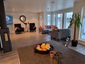 una sala de estar con un bol de fruta en una mesa en Kaldfjord Sea House, en Tromsø
