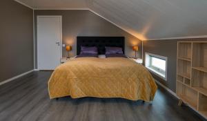 a bedroom with a large bed with purple pillows at Kaldfjord Sea House in Tromsø
