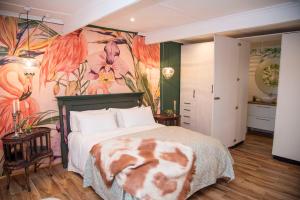 a bedroom with a large bed with a flower mural at La Lupa Nera in Knysna