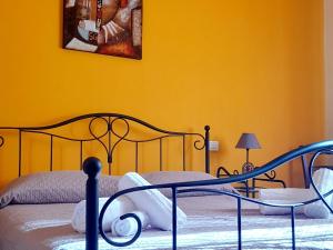 - une chambre avec un lit et un mur jaune dans l'établissement Su Fassoi Cabras, à Cabras