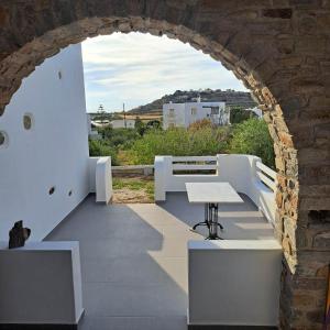 an archway in a building with a table and benches at stegio in Parasporos