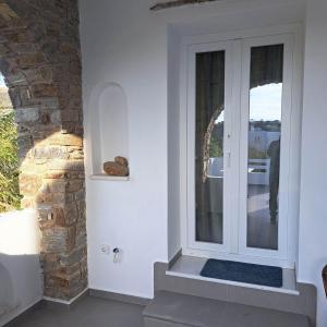 a white door in a room with a stone wall at stegio in Parasporos