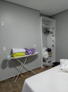 a room with a bed and a shelf with towels at Casa Linda e Aconchegante in Manaus