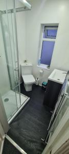 uma casa de banho com um chuveiro, um WC e um lavatório. em Sheffield City Suites em Manor